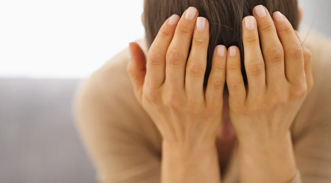 手で顔を覆う女性